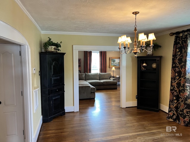 unfurnished dining area featuring ornamental molding, dark hardwood / wood-style floors, a textured ceiling, and a notable chandelier