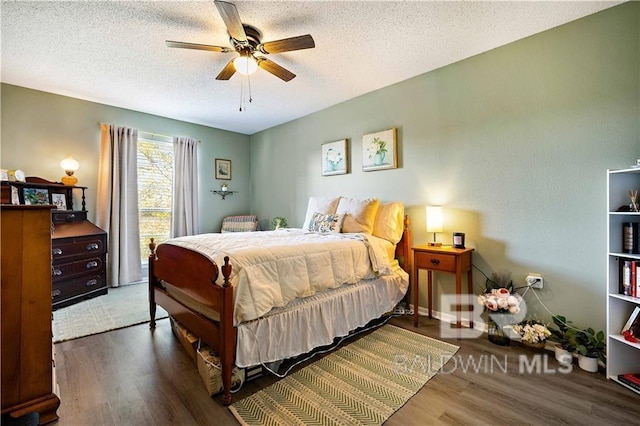 bedroom with ceiling fan, dark wood-type flooring, and a textured ceiling