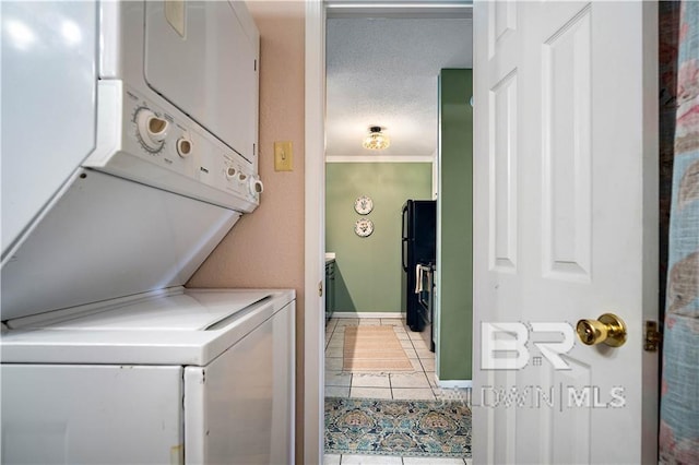 washroom with stacked washer and dryer, tile patterned floors, and ornamental molding