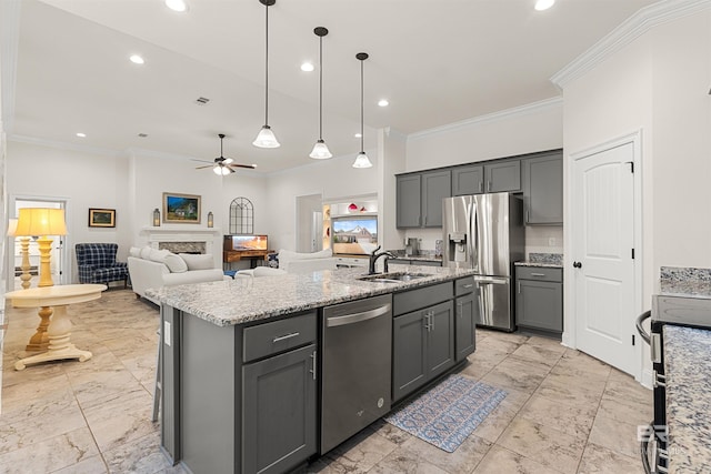 kitchen featuring sink, gray cabinets, an island with sink, pendant lighting, and stainless steel appliances