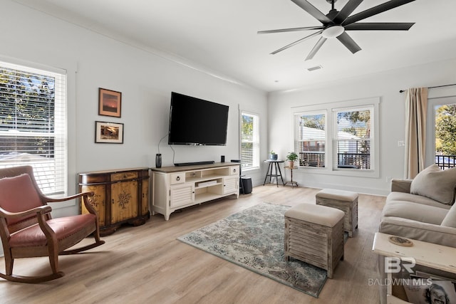 living room featuring light wood finished floors, ceiling fan, and visible vents