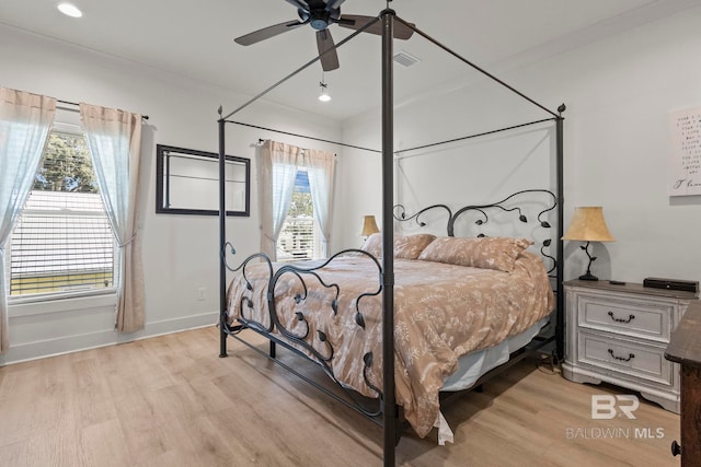 bedroom featuring multiple windows, recessed lighting, light wood-style flooring, and baseboards