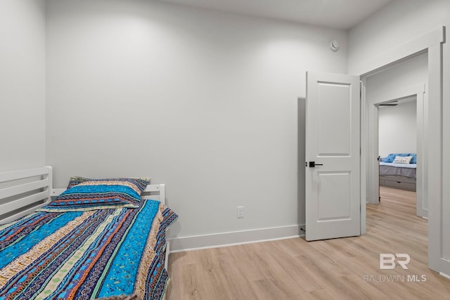 bedroom with light wood-style floors and baseboards