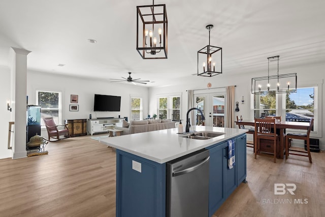 kitchen with light wood-style floors, dishwasher, french doors, blue cabinetry, and a sink