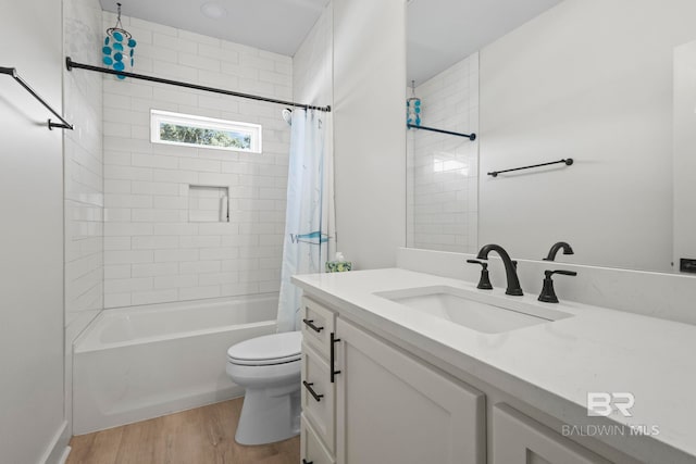 full bath featuring vanity, wood finished floors, toilet, and shower / bathtub combination with curtain