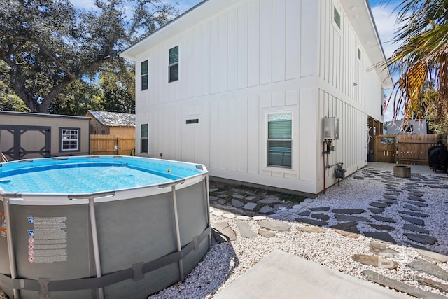 back of house featuring an outdoor structure, fence, and a fenced in pool