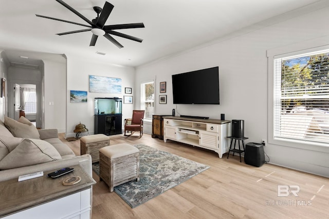 living room featuring a ceiling fan, plenty of natural light, visible vents, and light wood-style floors