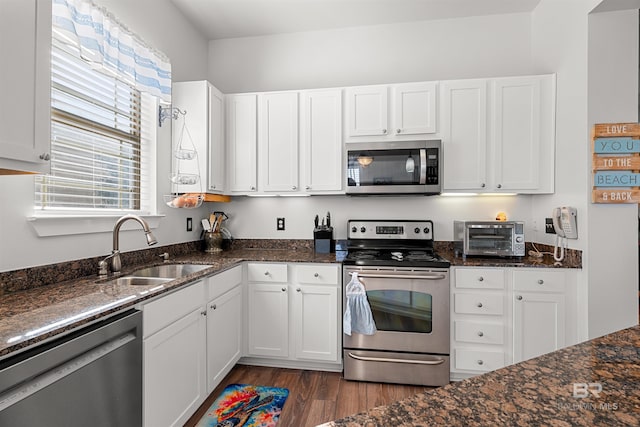 kitchen featuring dark wood-style floors, a toaster, a sink, appliances with stainless steel finishes, and white cabinetry