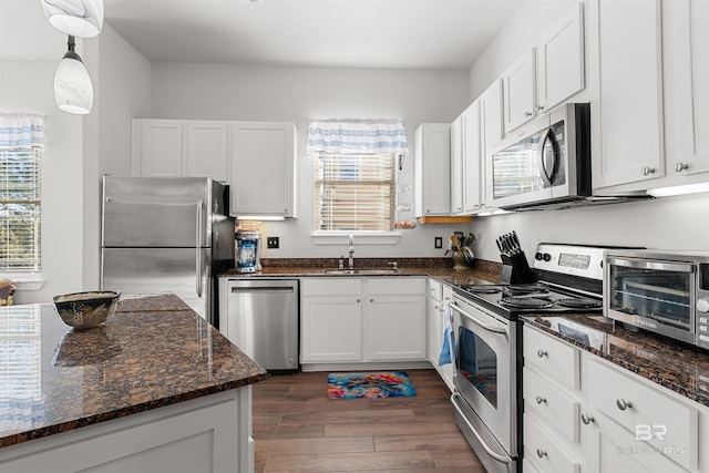 kitchen with white cabinetry, dark wood-style floors, appliances with stainless steel finishes, and a sink