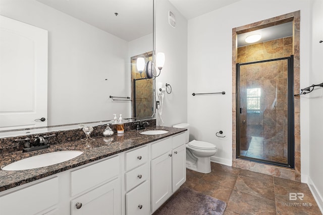 full bath with double vanity, a stall shower, toilet, and a sink