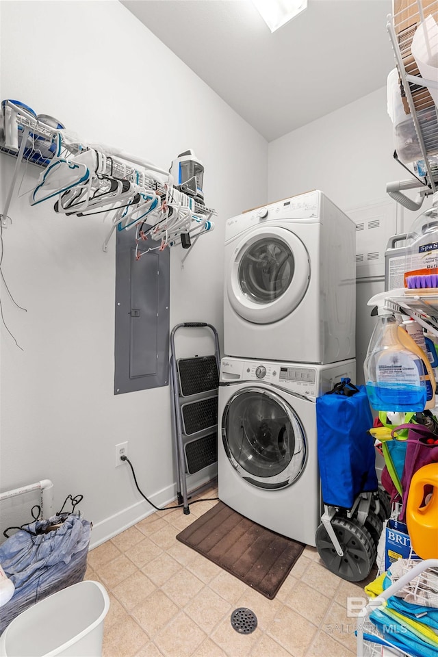 clothes washing area with laundry area, stacked washer and dryer, electric panel, and light floors