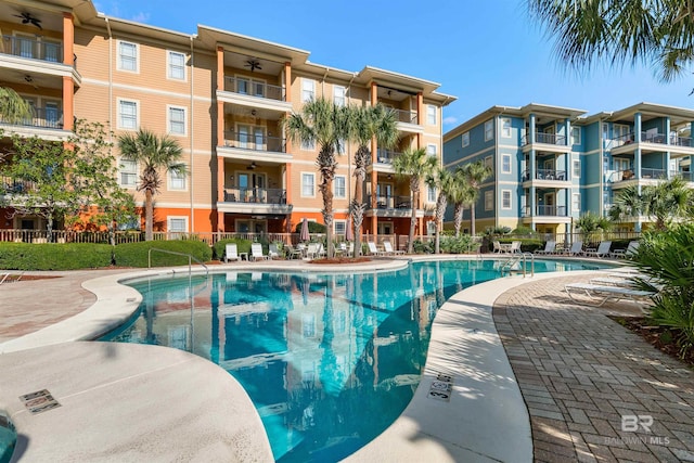 pool with a patio and fence