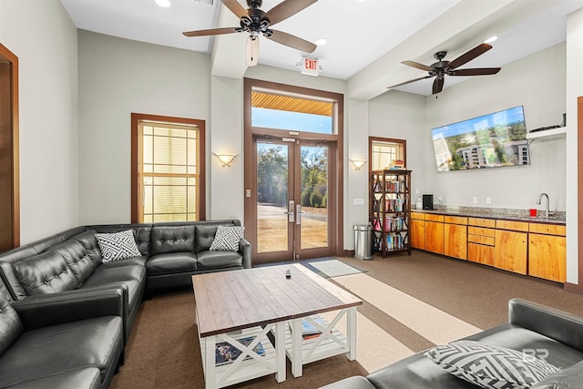 carpeted living area with wet bar, recessed lighting, a sink, ceiling fan, and french doors