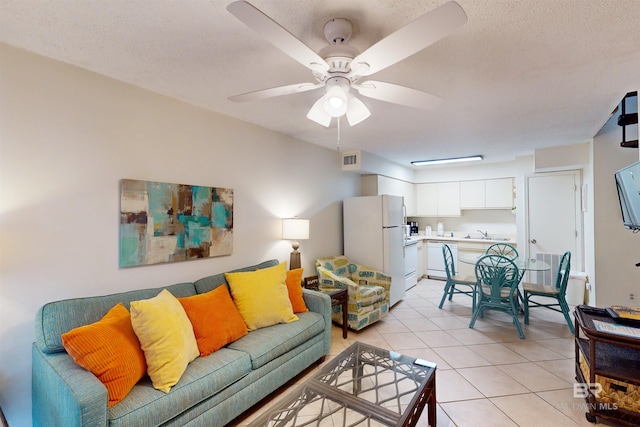 tiled living room with ceiling fan, a textured ceiling, and sink