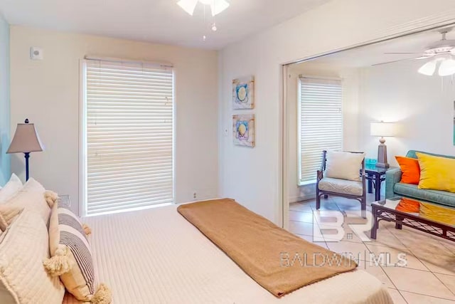 tiled bedroom featuring ceiling fan