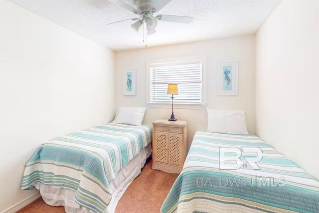 bedroom with ceiling fan, light colored carpet, and a textured ceiling