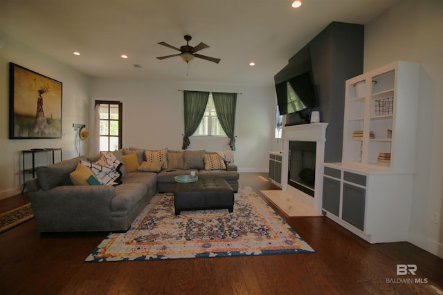 living room with dark wood-type flooring and ceiling fan