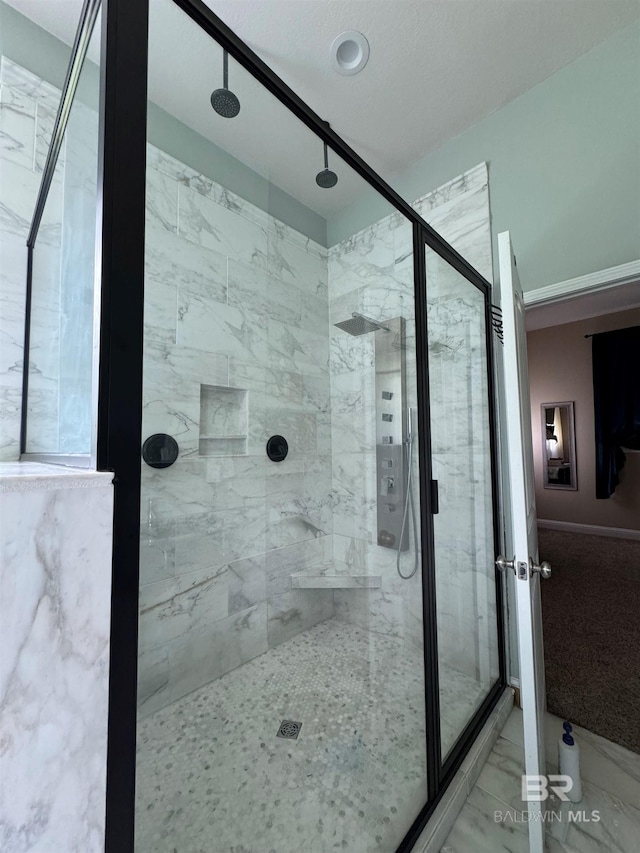 bathroom with a shower with shower door and tile patterned flooring