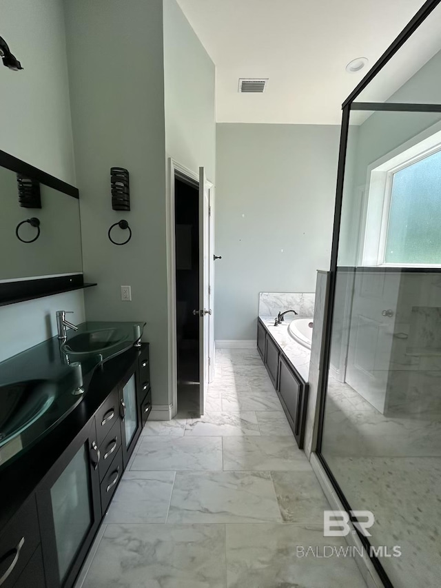 bathroom with dual bowl vanity, tile patterned floors, and separate shower and tub