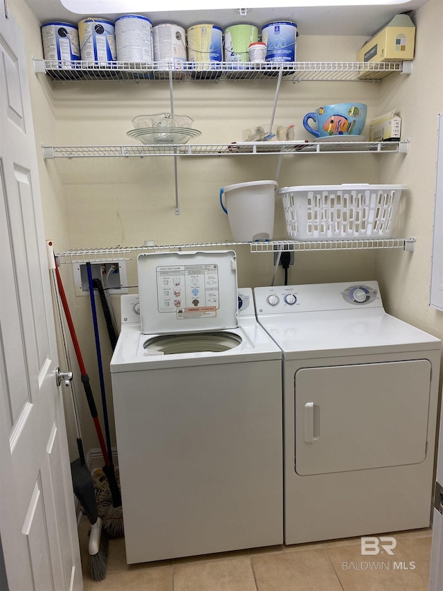 laundry room with washer and dryer and light tile patterned floors