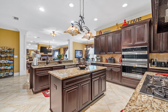 kitchen with dark brown cabinets, tasteful backsplash, decorative light fixtures, sink, and appliances with stainless steel finishes