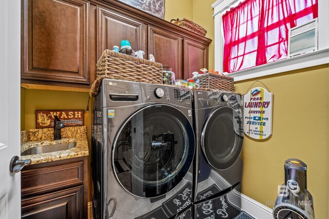 clothes washing area featuring cabinets, sink, and independent washer and dryer