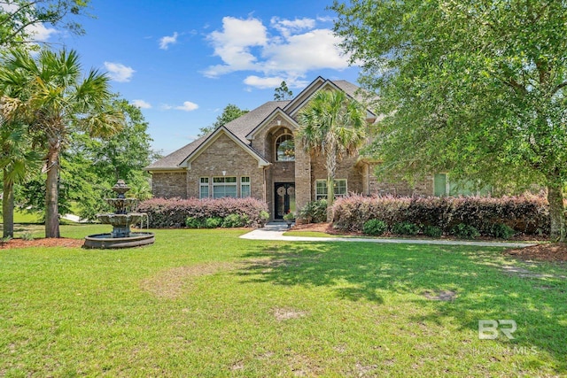 view of front facade with a front lawn and brick siding