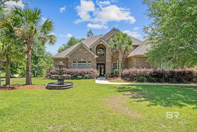 traditional-style home with brick siding, a front lawn, and a shingled roof