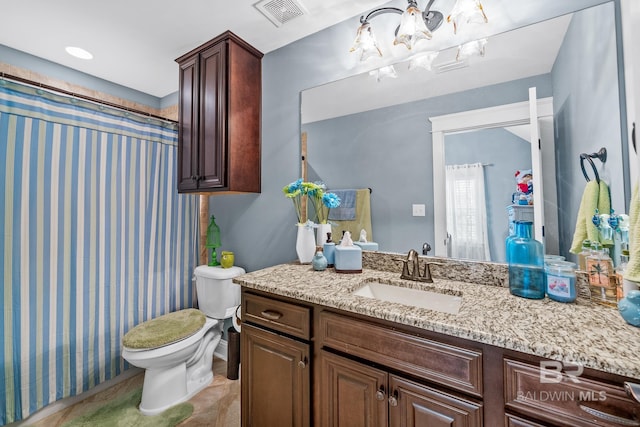 bathroom featuring tile flooring, vanity, toilet, and an inviting chandelier