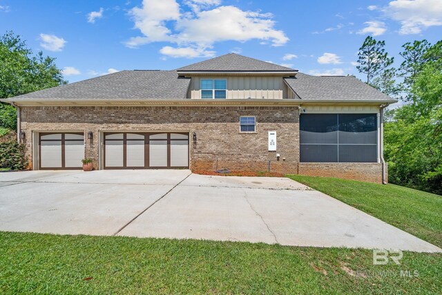 back of house featuring a garage and a lawn