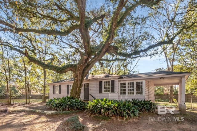 ranch-style house with a carport and fence