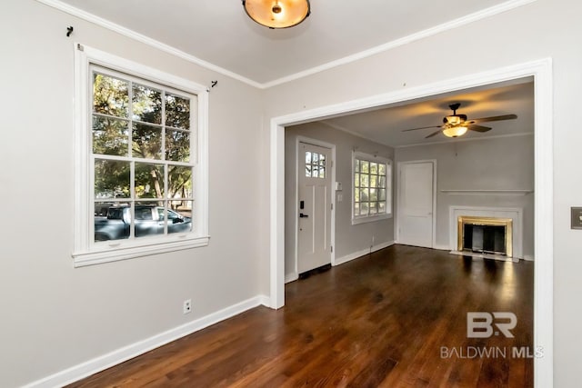 foyer with baseboards, a ceiling fan, a fireplace with flush hearth, wood finished floors, and crown molding