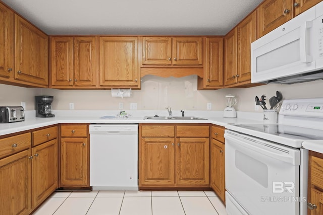 kitchen with sink, white appliances, and light tile patterned flooring