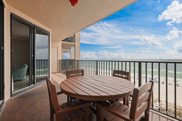 balcony featuring a view of the beach and a water view