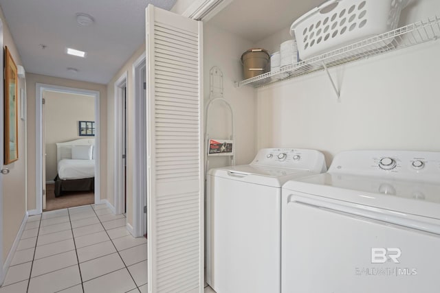 laundry area with light tile patterned floors and washing machine and dryer