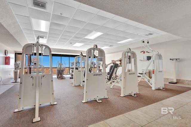 gym with tile patterned floors and a drop ceiling