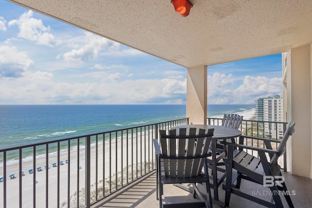 balcony featuring a beach view and a water view