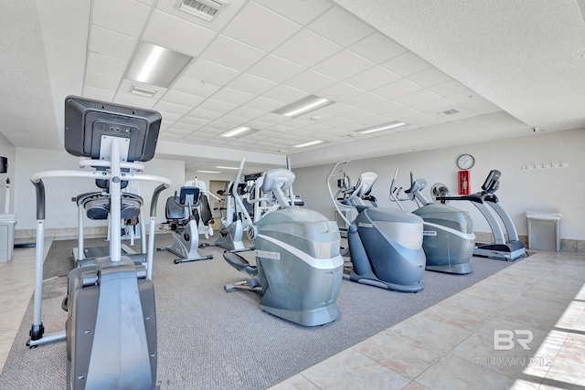 workout area with tile patterned flooring and a drop ceiling