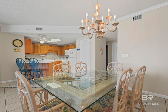 tiled dining room featuring ceiling fan with notable chandelier, a textured ceiling, and ornamental molding