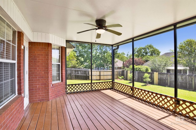 unfurnished sunroom with a ceiling fan