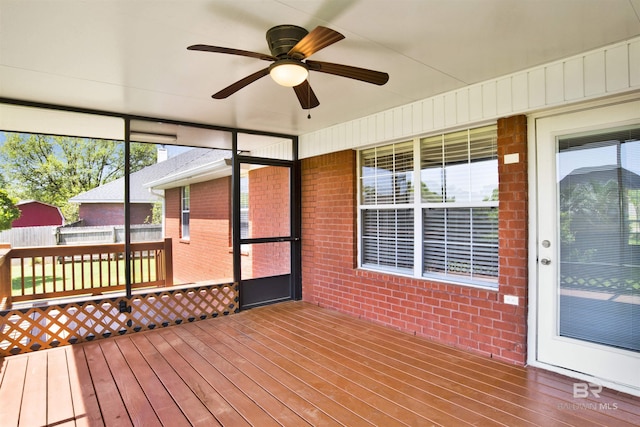 unfurnished sunroom featuring ceiling fan