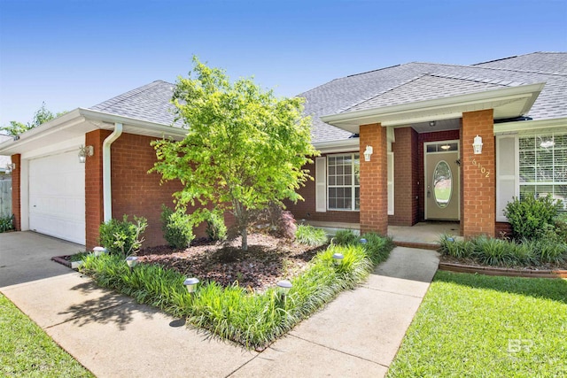 single story home featuring brick siding, concrete driveway, a garage, and roof with shingles
