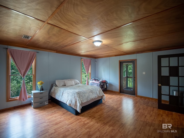 bedroom featuring visible vents, wood finished floors, wooden ceiling, and access to outside