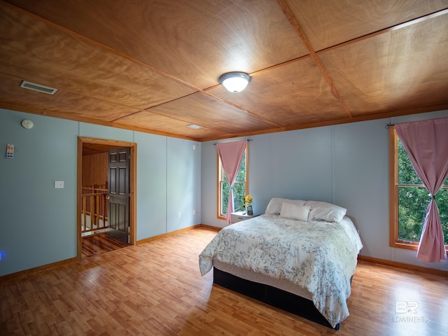 bedroom featuring baseboards, visible vents, and wood finished floors