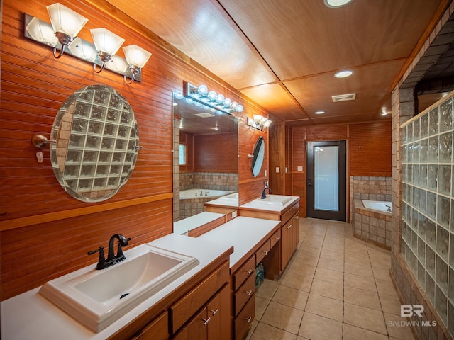 bathroom with tile patterned floors, a sink, two vanities, a bath, and visible vents