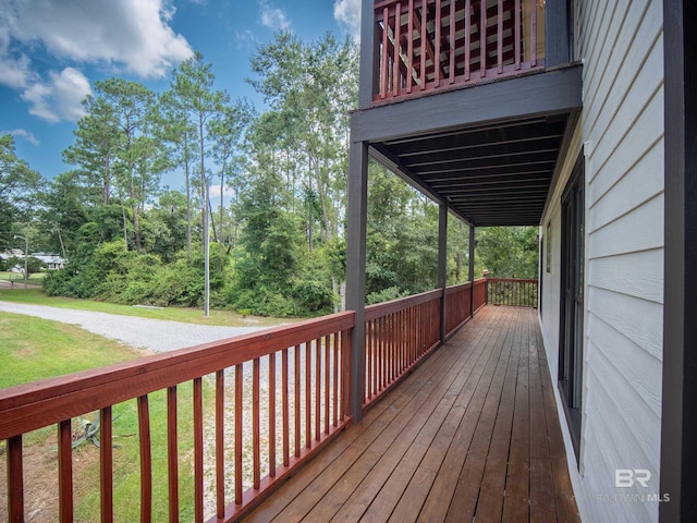 wooden terrace featuring a lawn