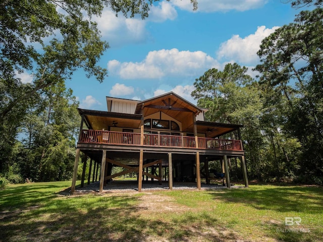 rear view of house featuring a lawn, a wooden deck, board and batten siding, and a carport