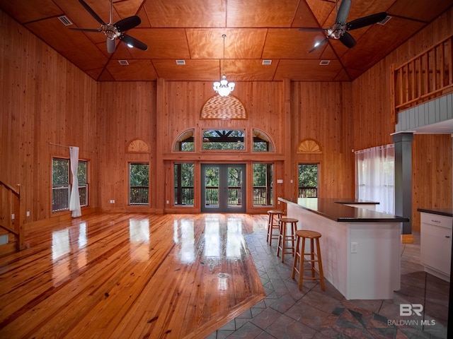 kitchen featuring wood walls, dark countertops, a ceiling fan, and open floor plan