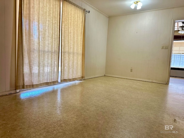 unfurnished room with ceiling fan and ornamental molding