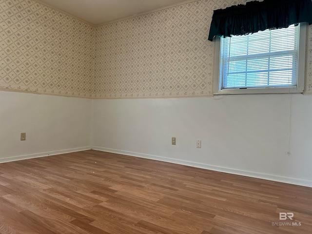 spare room with crown molding and light hardwood / wood-style flooring